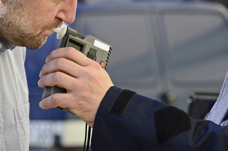 motorist taking a roadside breath test to measure BAC - the Nevada alcohol limit is .08%