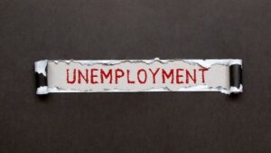 Door tag that is labeled "unemployment" against a dark background