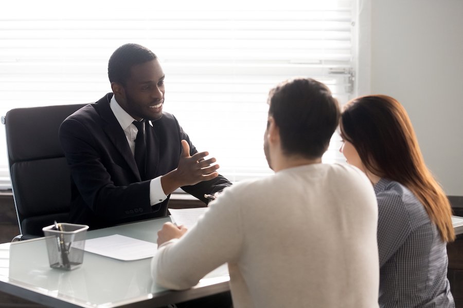 Lawyer at desk meeting with clients as an example of conversations protected by Attorney-Client Privilege in Nevada
