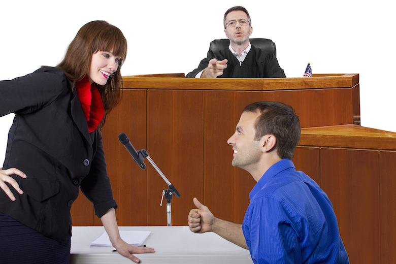Smiling criminal defense attorney attorney and her client in court in front of a judge against a white background