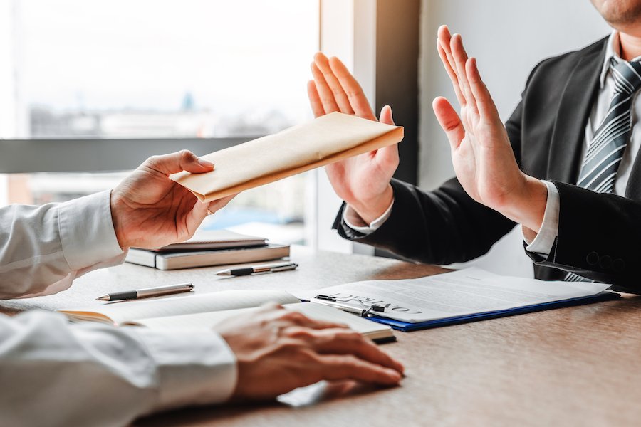 Man putting up hands refusing a bribe