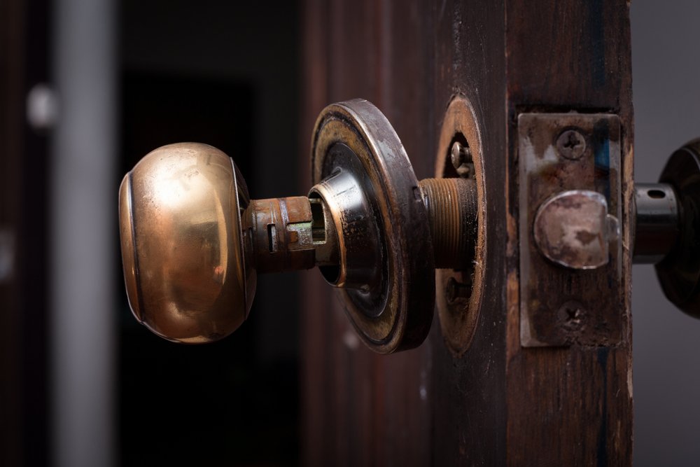 Closeup of a copper door handle broken off following an act of housebreaking