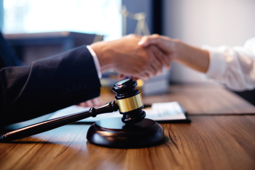 judge shaking hands with gavel in foreground