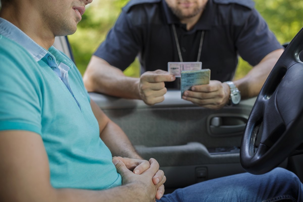 Traffic stop with a police officer examining the driver's license