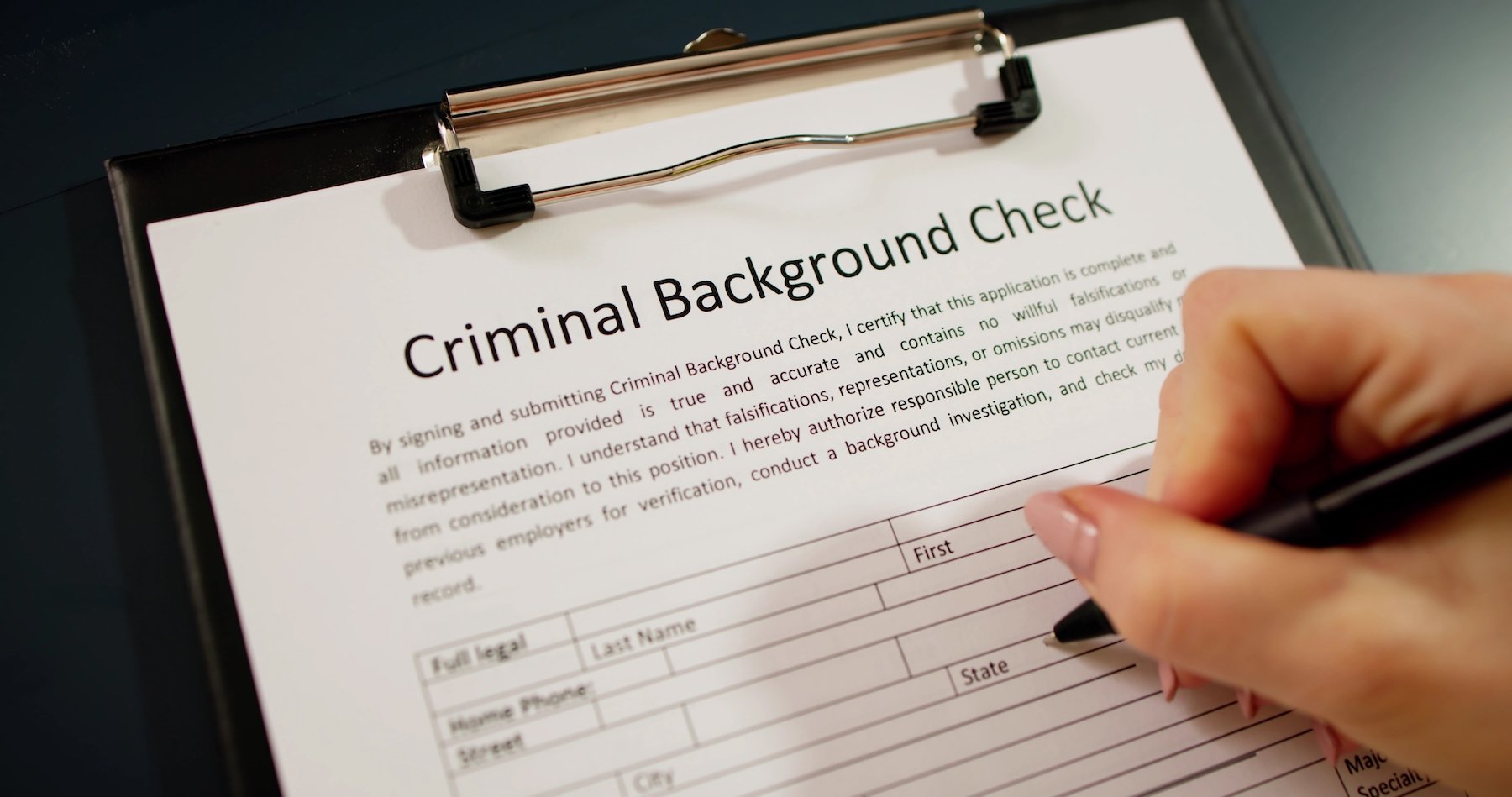 Clipboard with paper that says "criminal background check"