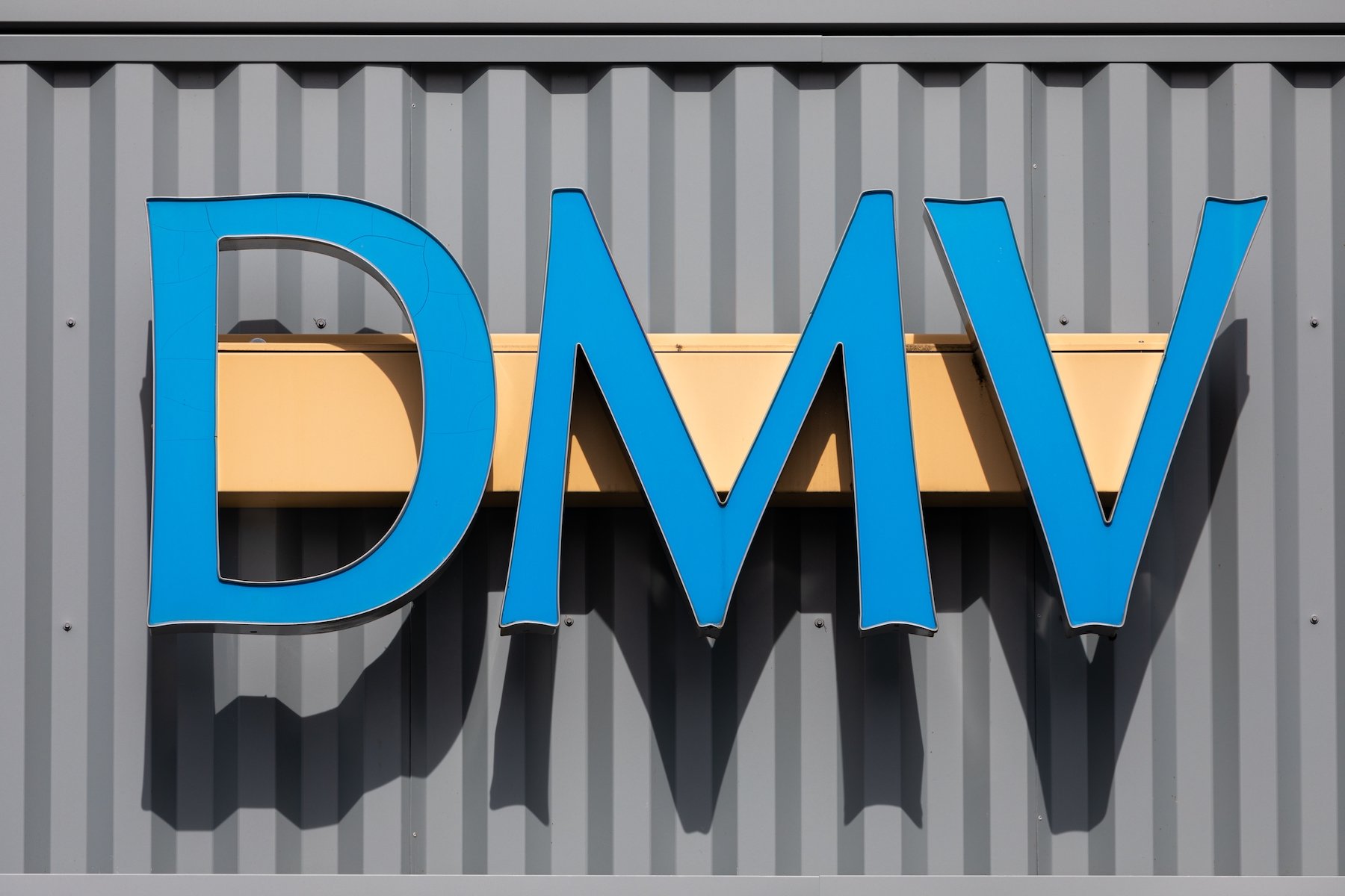 Blue DMV sign in front of DMV office