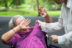 Elderly person being abused by caretaker in a park