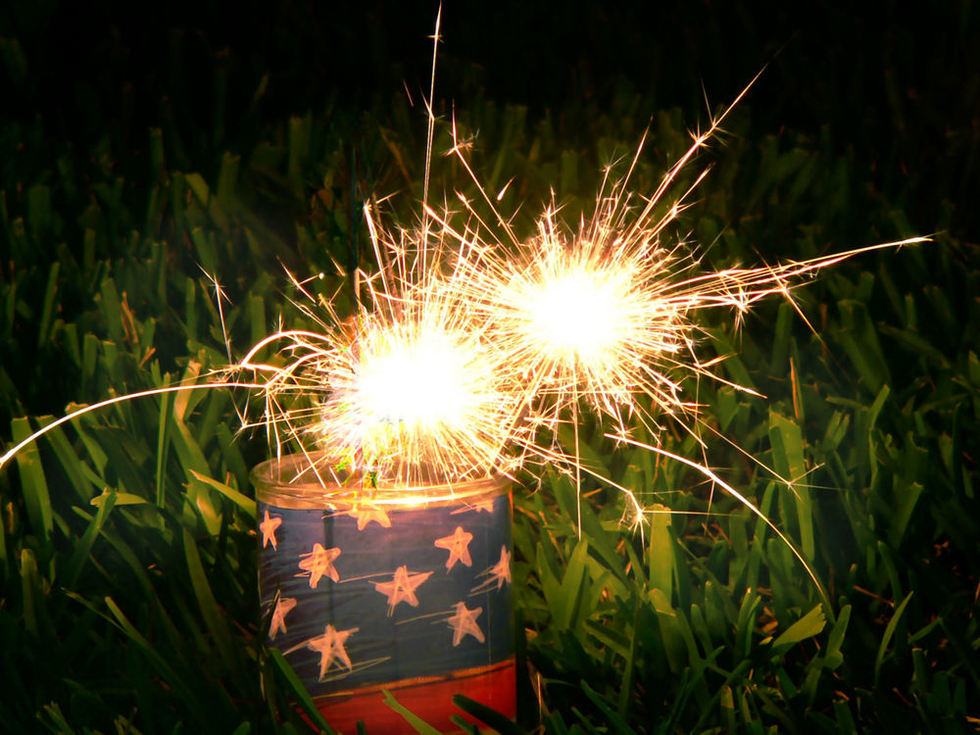Sparkler fireworks near an American flag on Fourth of July