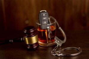 Whiskey with car keys, gavel, and handcuffs.