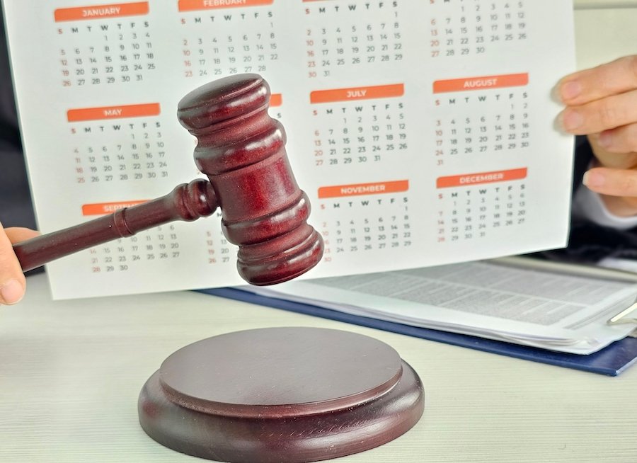 Judge's wooden gavel next to a year-calendar on a judge's desk