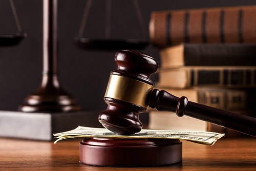 Gavel resting on a cash fine, which can resolve most misdemeanor cases in Nevada. 