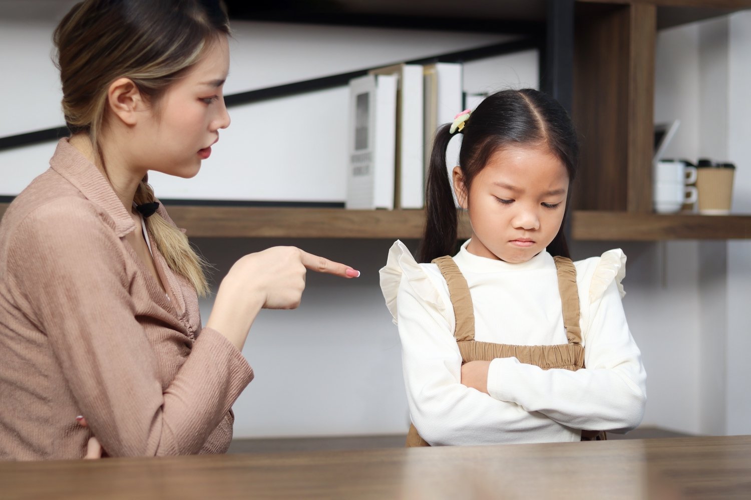 Woman scolding a young girl in a classroom