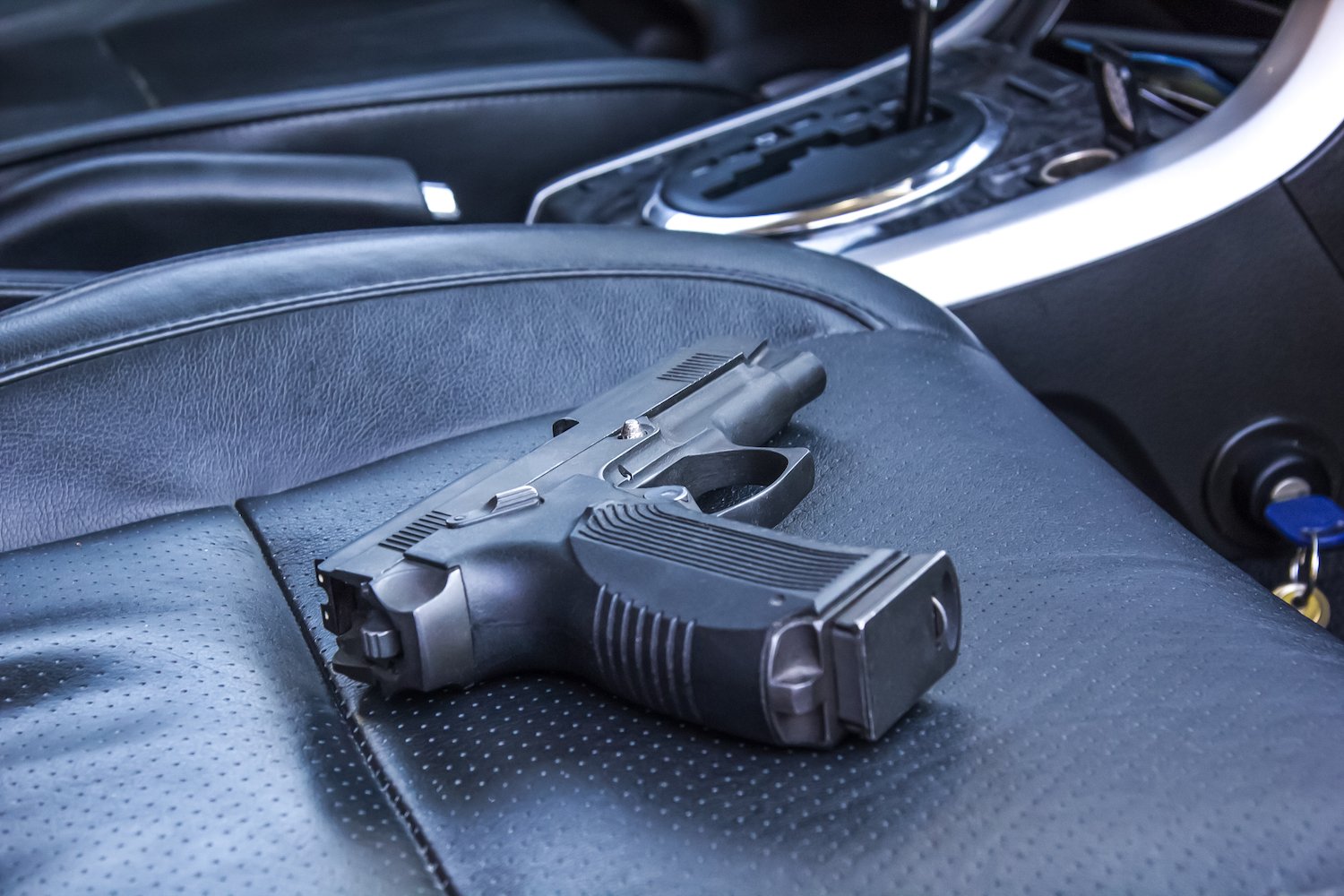 Handgun lying on a passenger seat in a car
