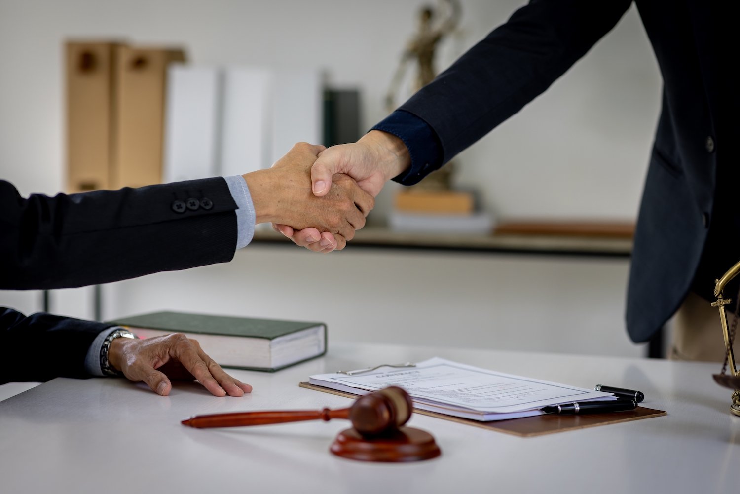 Two attorneys shaking hands after successfully negotiating a D.A. denial in Nevada
