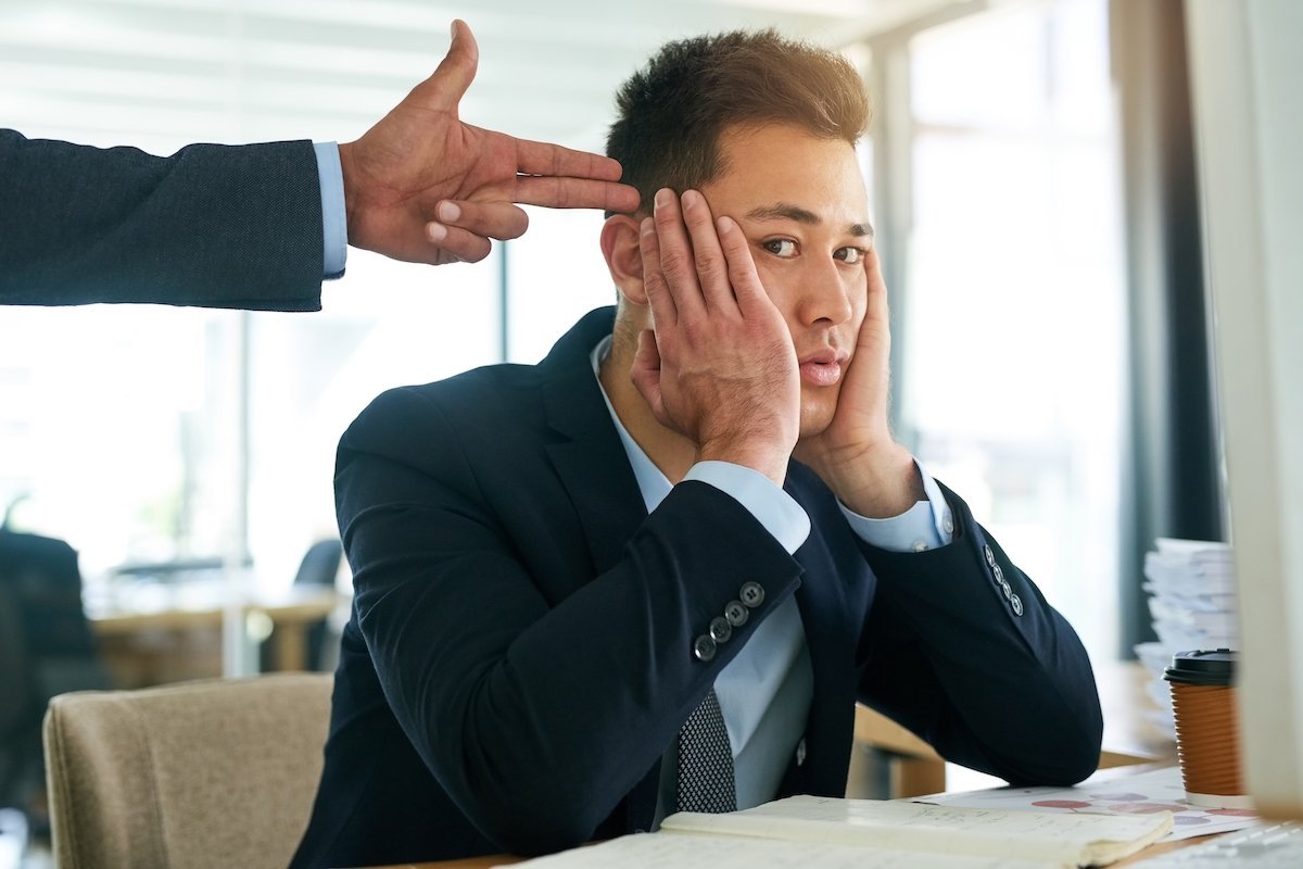 Workplace bully harassing an employee in an office