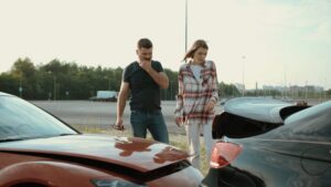 Two people surveying the damage after a fender bender