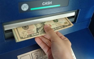 Person withdrawing money from an ATM machine