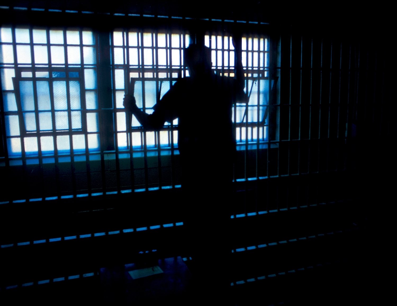 Inmate looking out of his jail cell window during the day