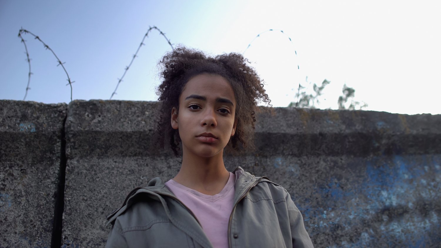 Teenage girl outside walking in the juvenile detention prison yard
