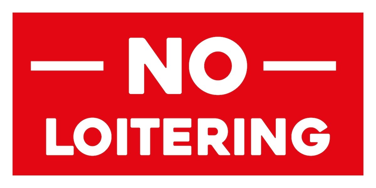 "No Loitering" sign with white letters against red background