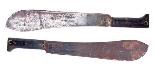 two worn machetes against a white background