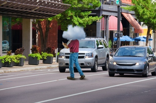 Man with head in the clouds jaywalking