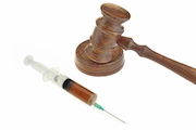 Judge's gavel next to a hypodermic needle