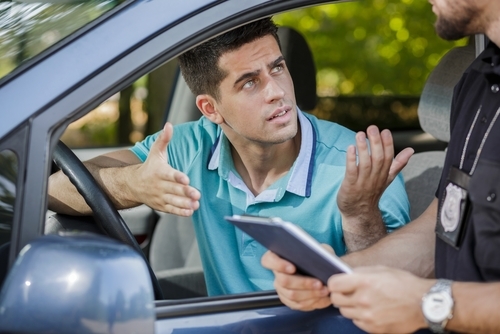 Driver arguing with a police officer who is trying to give him a ticket