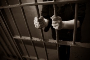 inmate's hands gripping prison bars