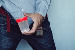 Man holding urine cup during a probation check-in