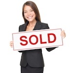 Woman holding "Sold" sign