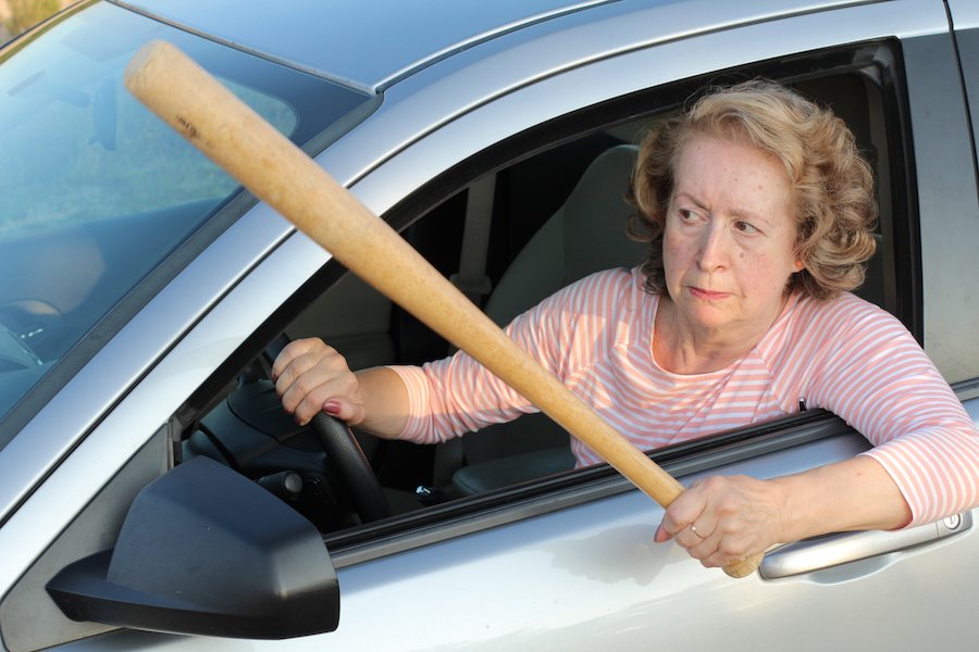 Female driver holding out a baseball bat in a fit of road rage