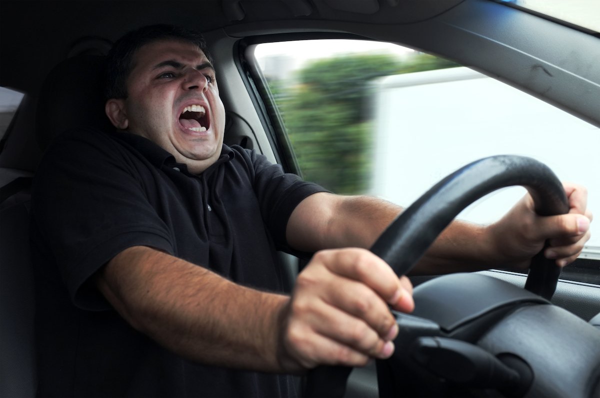Angry driver gripping his steering wheel in a fit of road rage