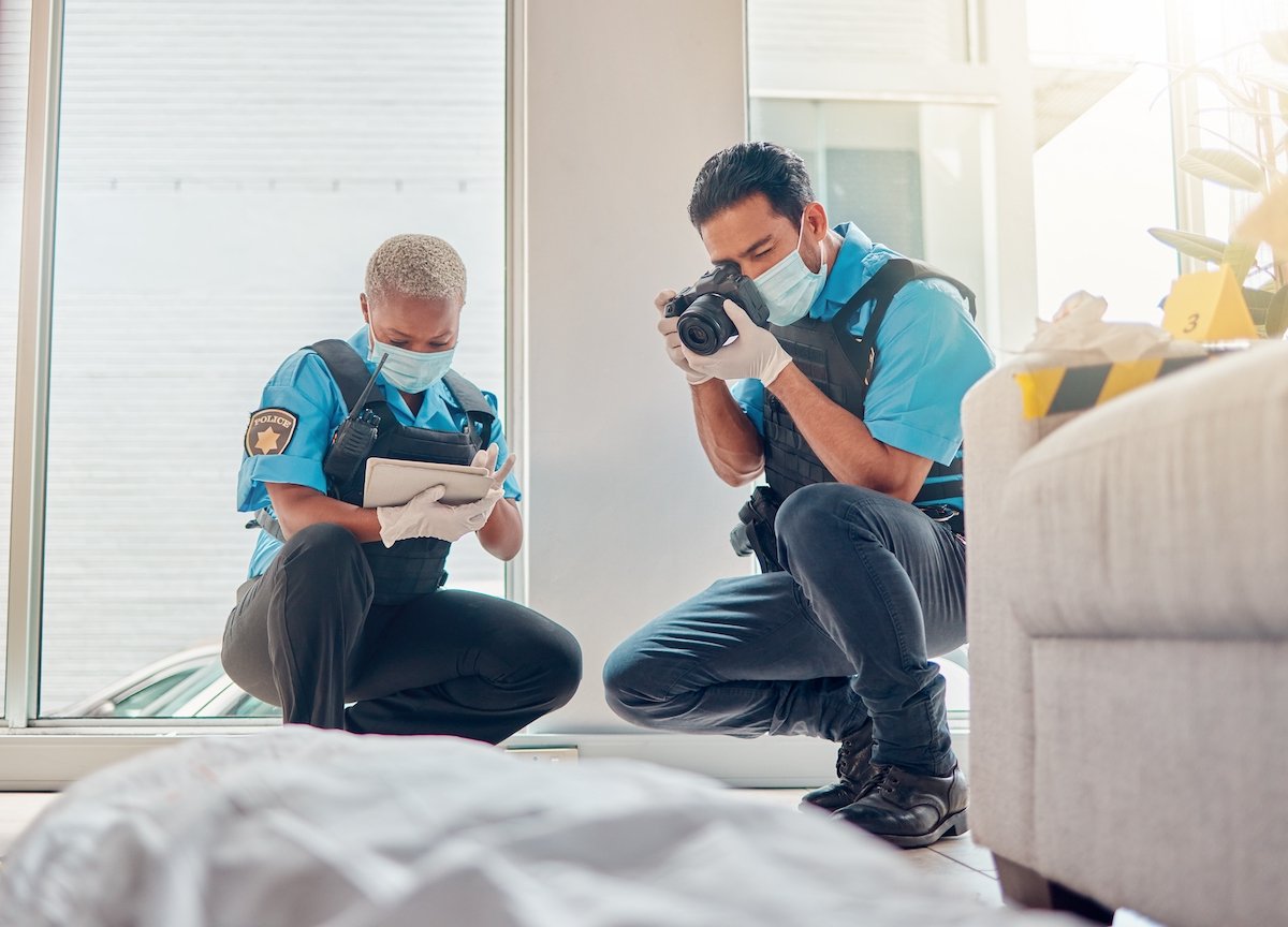 Two detectives photographing a crime scene
