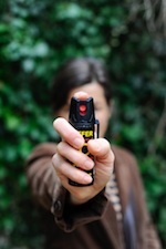 Person aiming a gun to assailant behind the camera with trees in the background