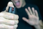 Screaming man spraying pepper spray to assailant behind the camera
