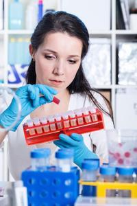 Chemist testing vial of blood in a laboratory