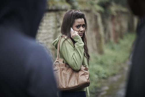 woman on phone who is being stalked as an example of an NRS 200.575 situation