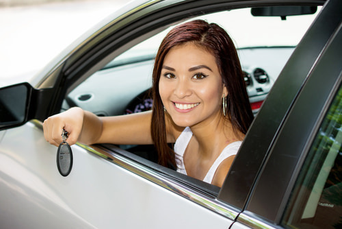 Happy teen who is driving with her new driver's license.