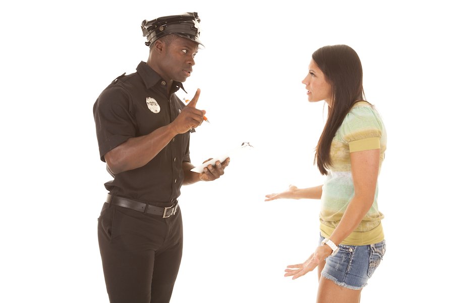 Policeman detaining female suspect against a white background