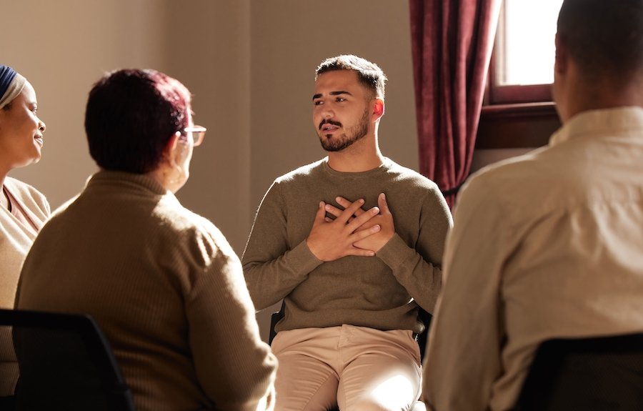 Group therapy for substance abuse in a small room with a window