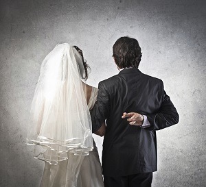 Bride with groom crossing his fingers
