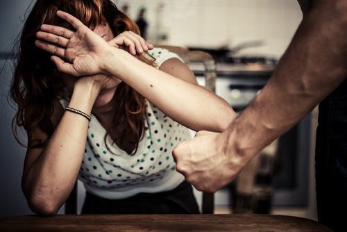 Man violating NRS 200.485 by punching his girlfriend, who is shielding her face with her hands